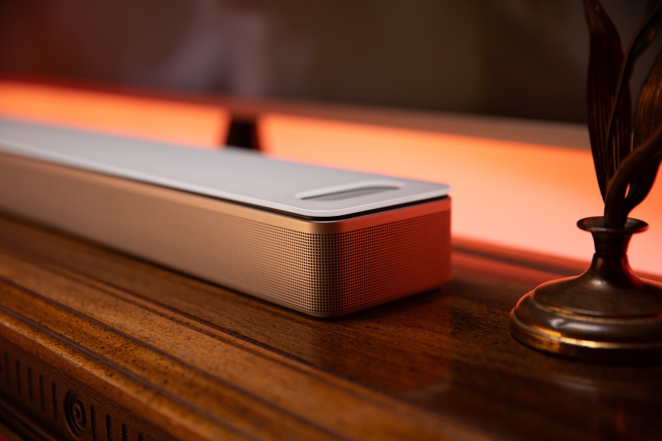 The Bose Smart Ultra Soundbar in close-up, warm light behind