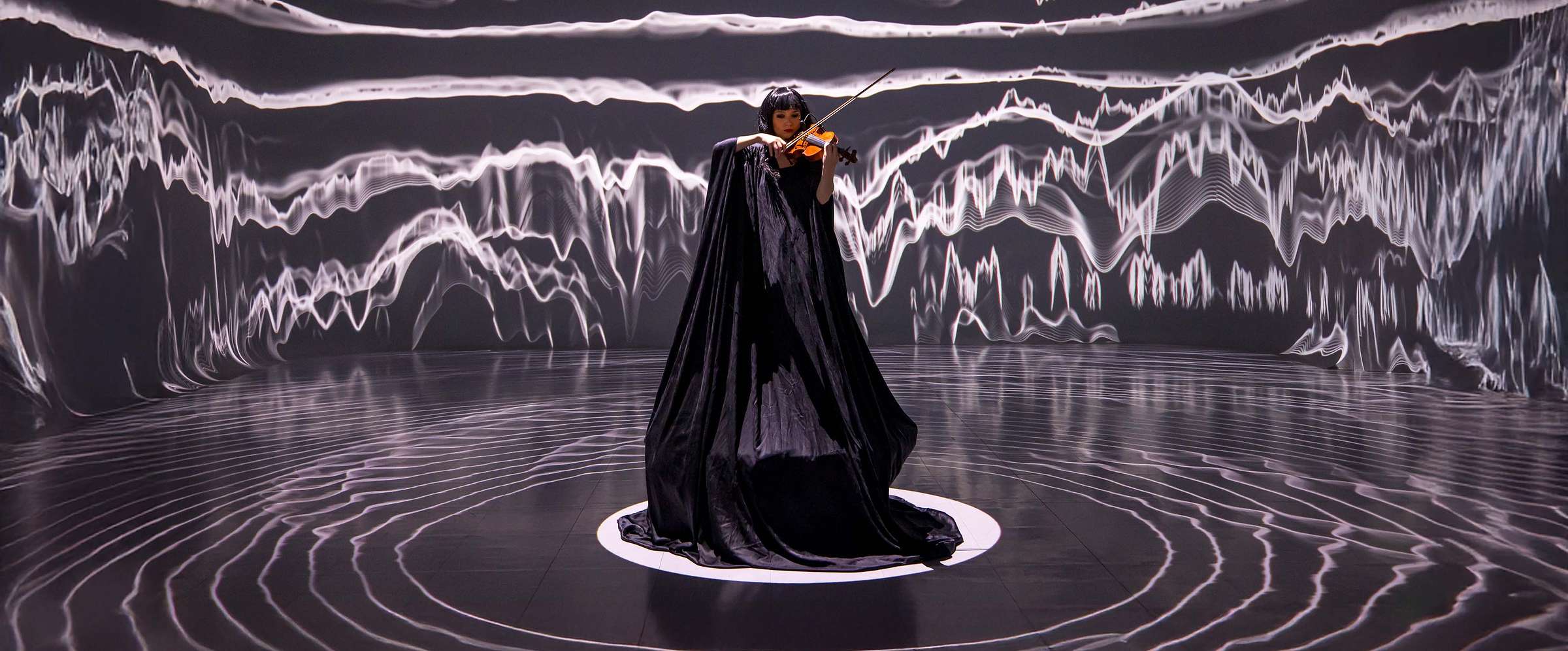 CAMP, violinist in a projection-mapped waveform environment
