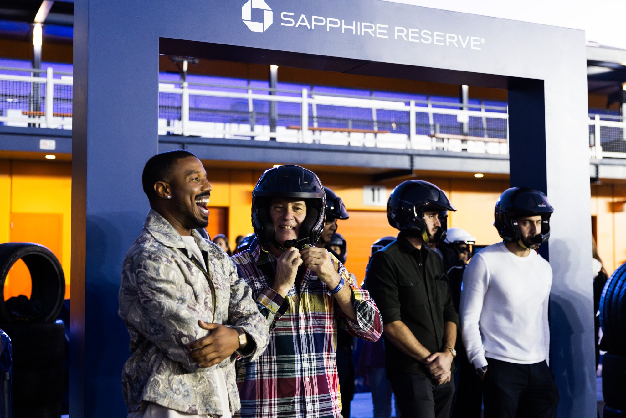 A guest is helped into a helmet under the Sapphire Reserve arch before driving