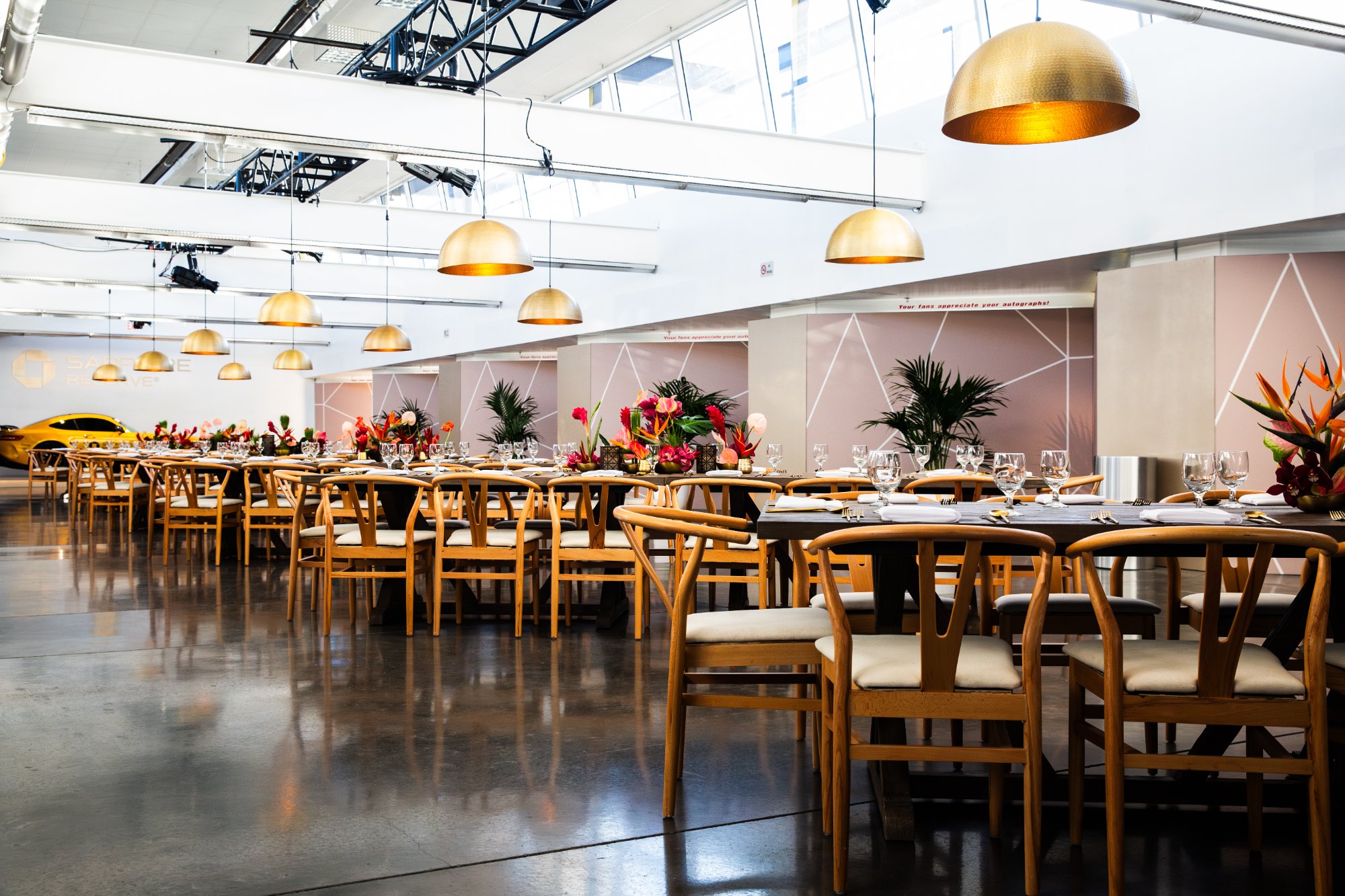 The dinner hall under hammered-gold dome lamps, set for service