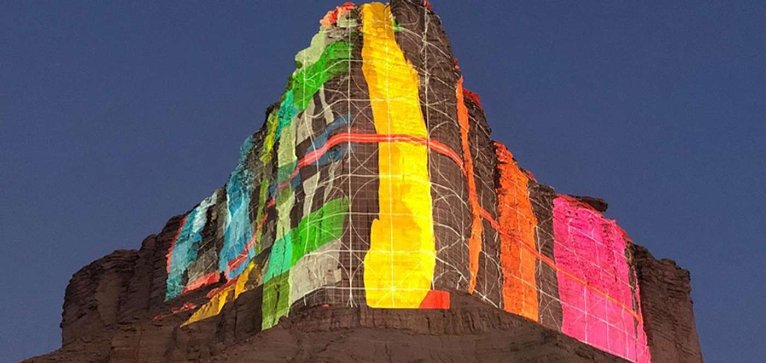 A daytime calibration test, color bars and a wireframe mapped across the cliff