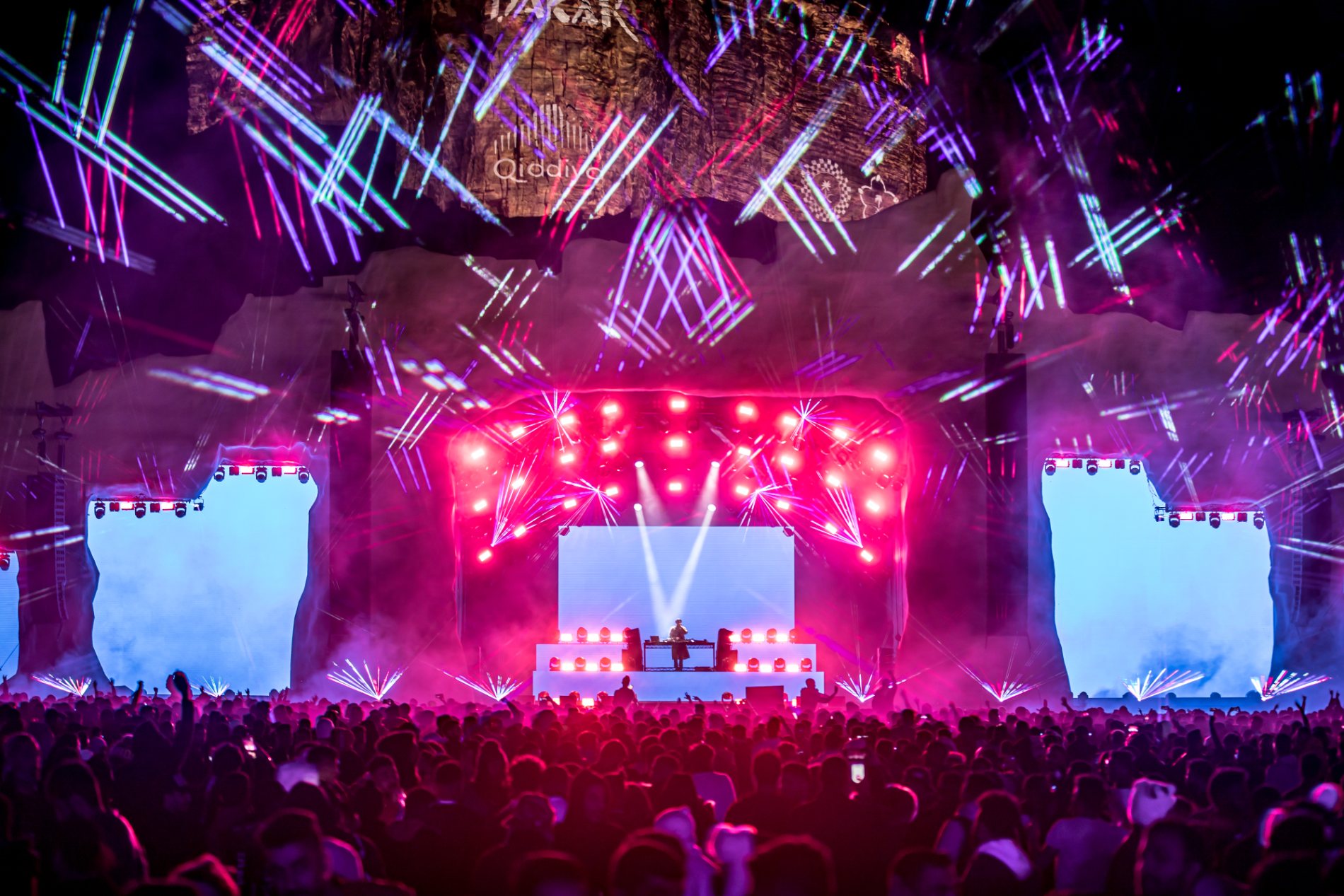 DJ Snake's set, lasers raking pink and blue over a packed desert crowd