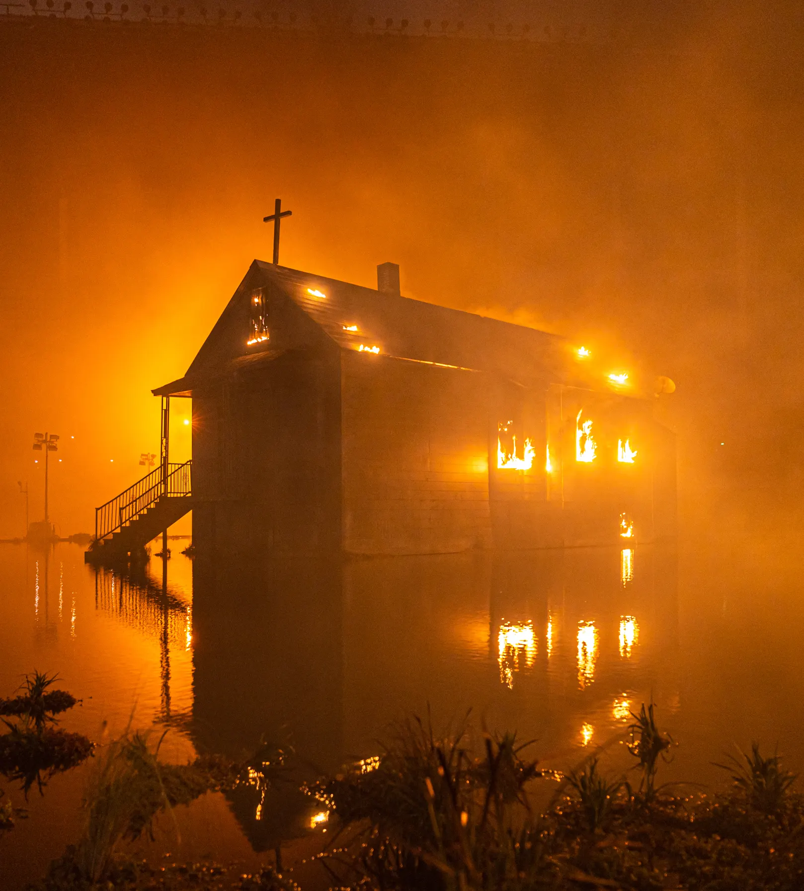 DONDA 2 listening event, burning house set reflected in water