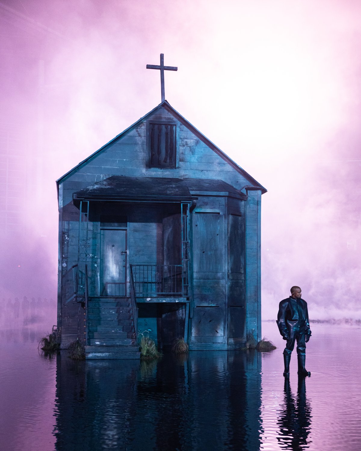 The replica house standing on still water under a wall of pink smoke