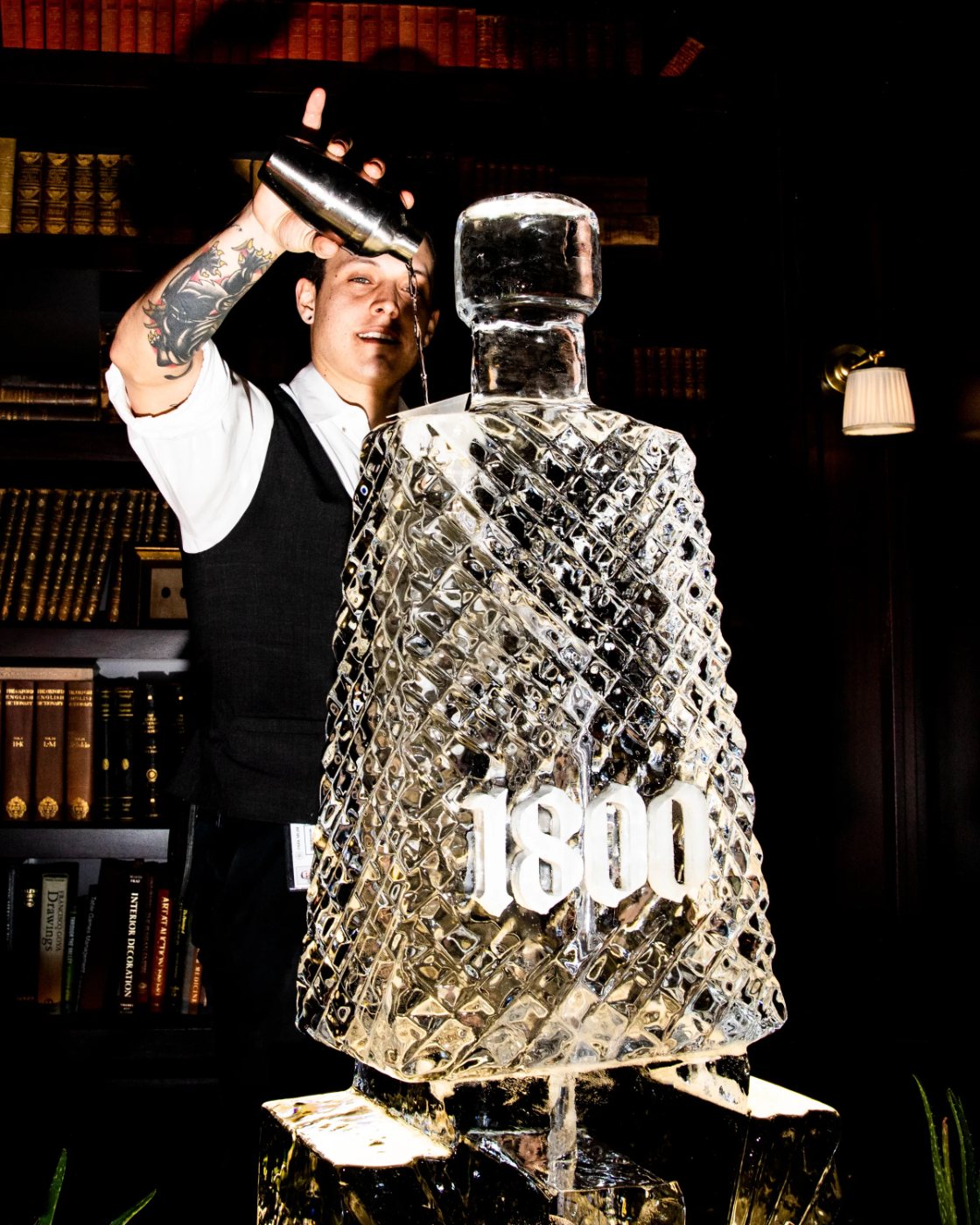 A bartender pours over a carved 1800 ice bottle in the library
