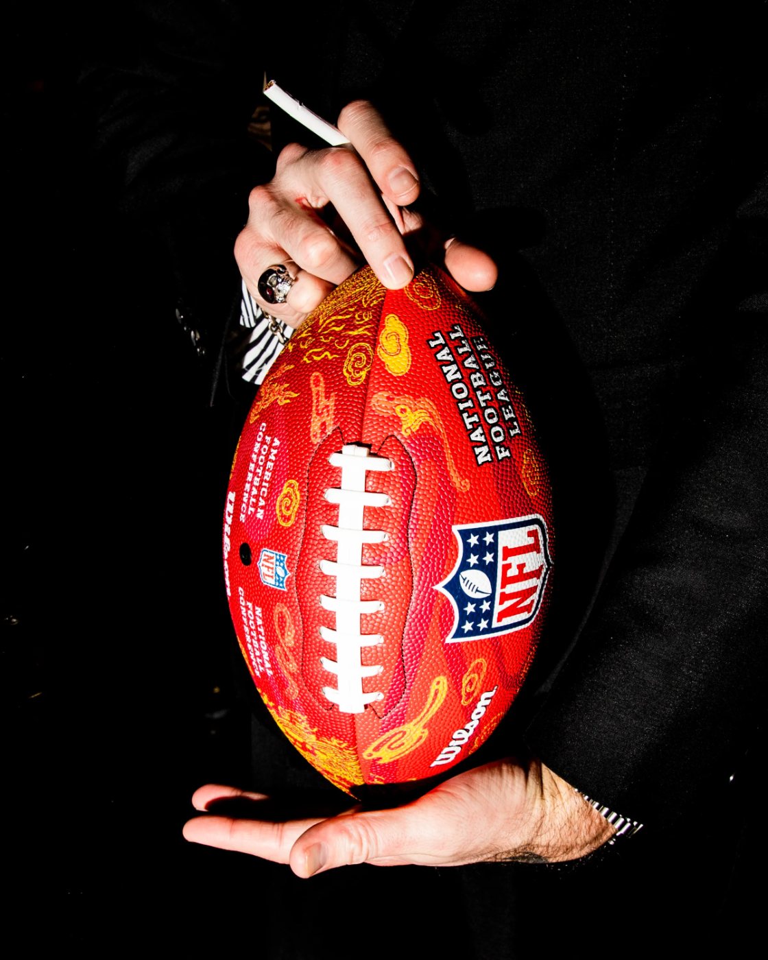 A guest holds a custom flame-pattern NFL football