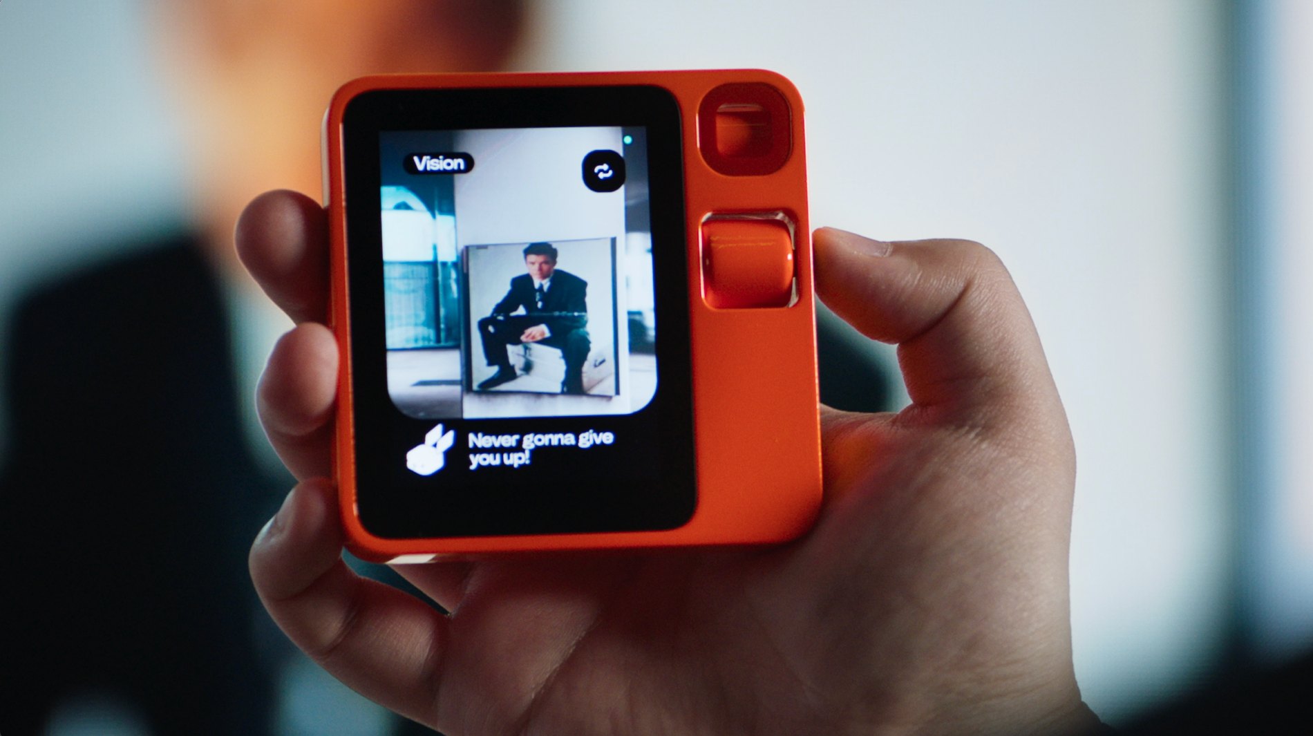 The r1's Vision feature shown on the device screen, held in hand