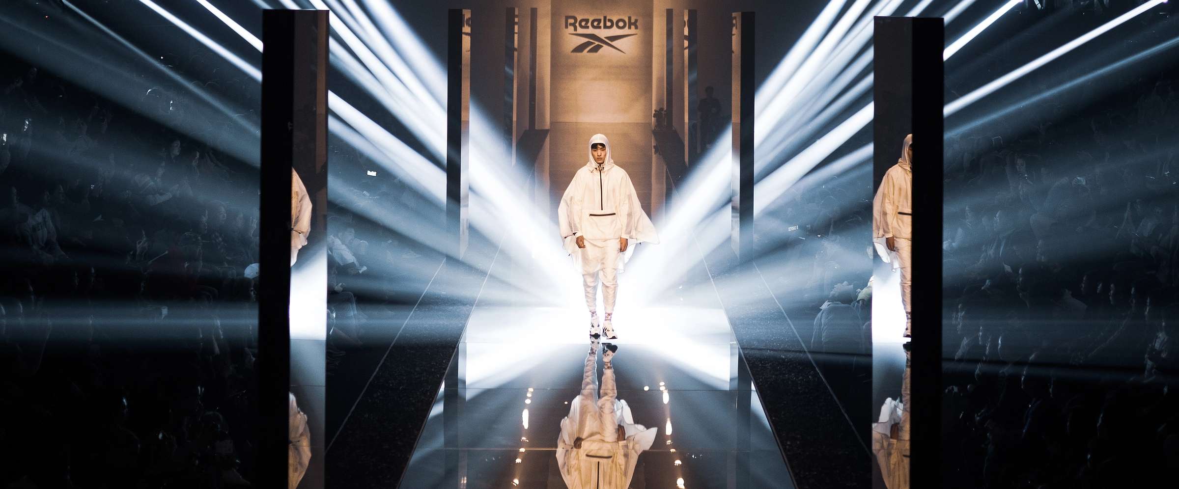 Reebok runway show with mirrored stage and beams of light
