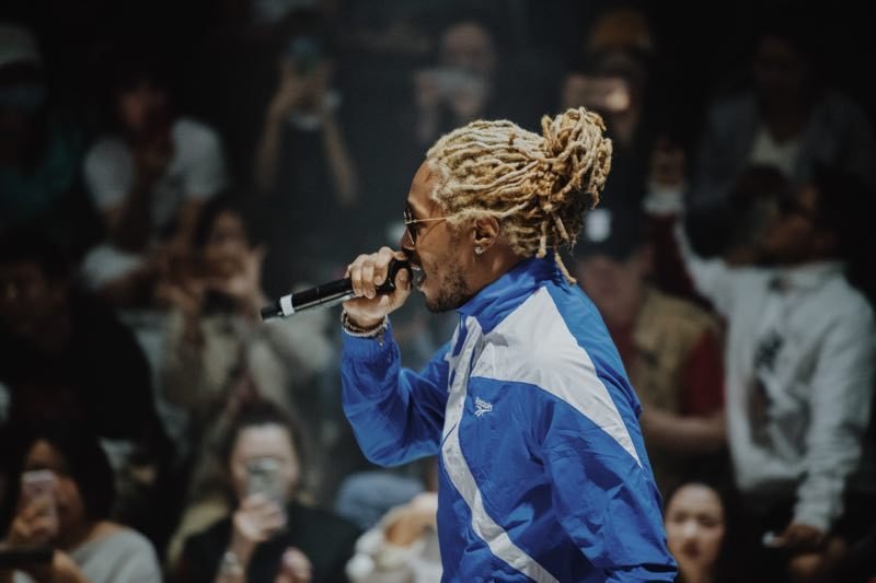 Future performs into the crowd in a blue Reebok jacket
