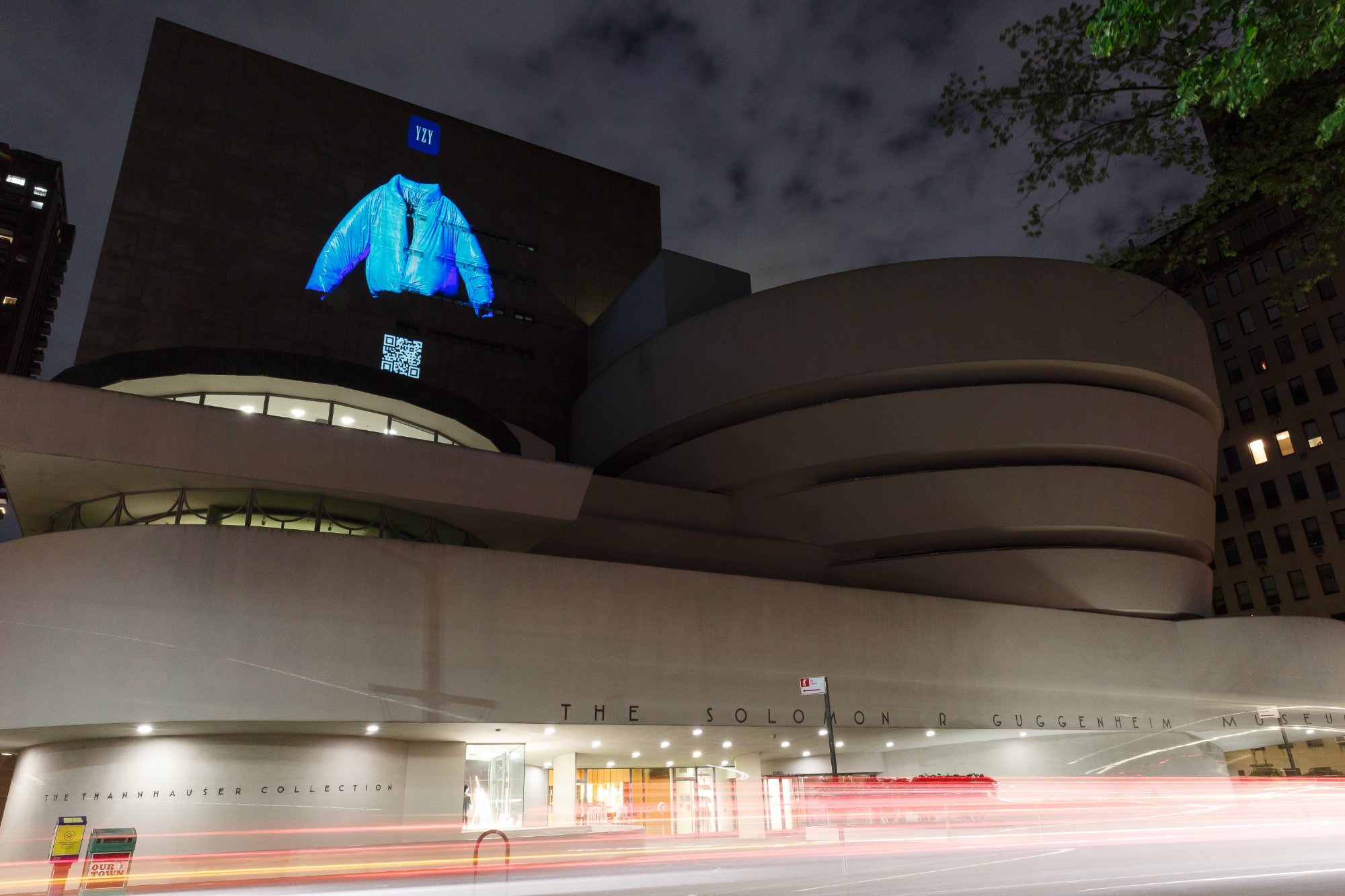 The blue Round Jacket and a QR code projected onto the Guggenheim Museum at night