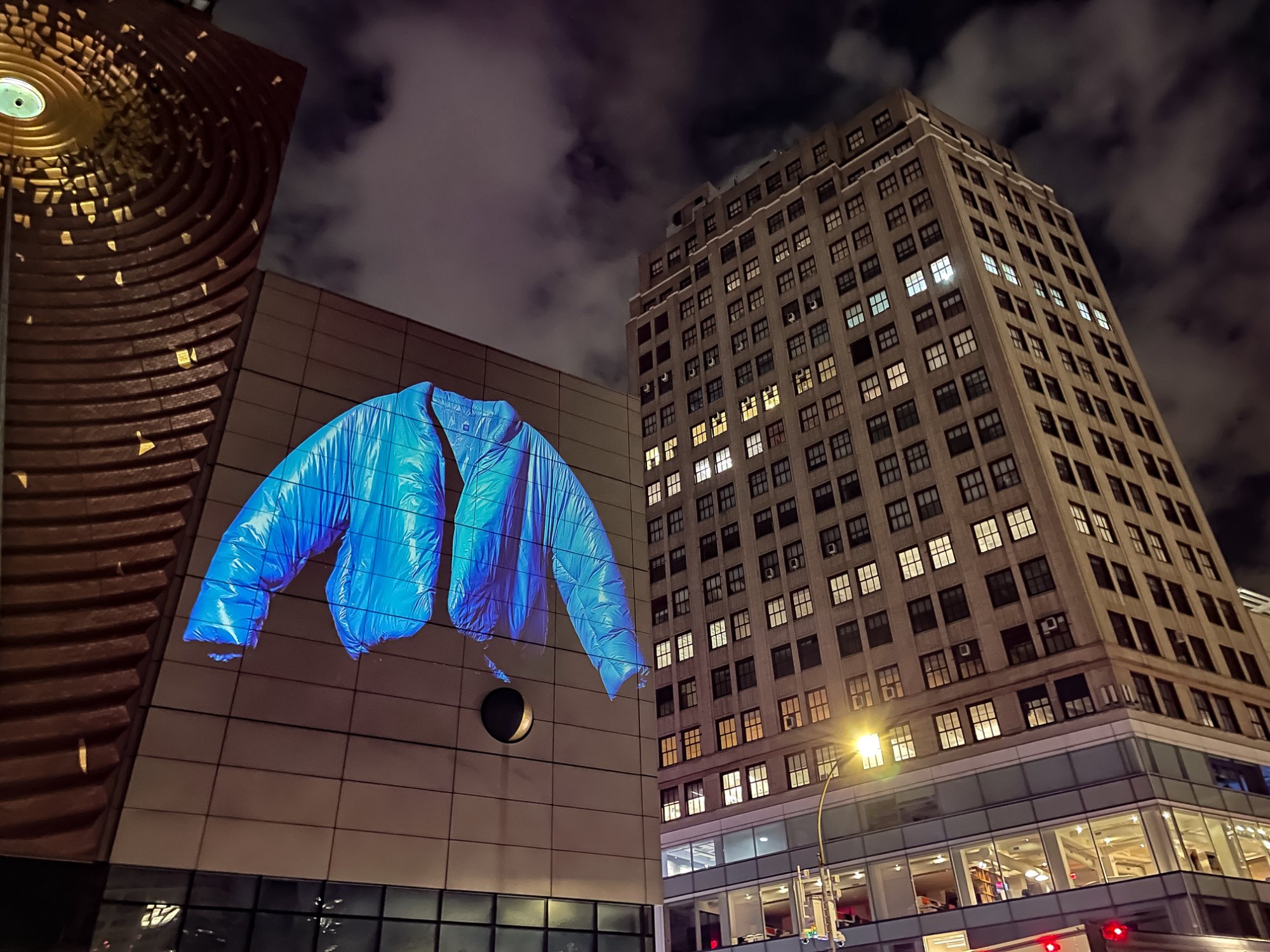 The Round Jacket projected on a building wall in New York at night
